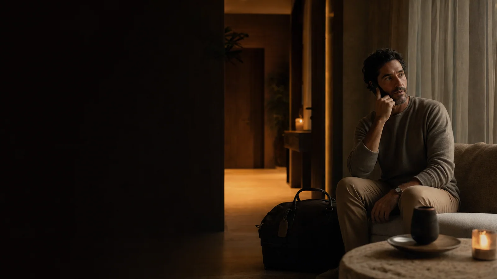 A guest receiving arrival guidance by phone at a warmly lit vacation rental before dawn